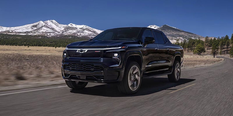 Black Chevrolet truck driving on a mountain road