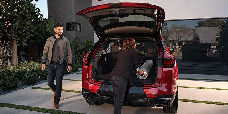 Open rear cargo area of a red Chevrolet SUV in a residential driveway