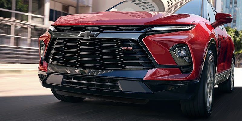 Close-up front view of a red Chevrolet SUV in motion