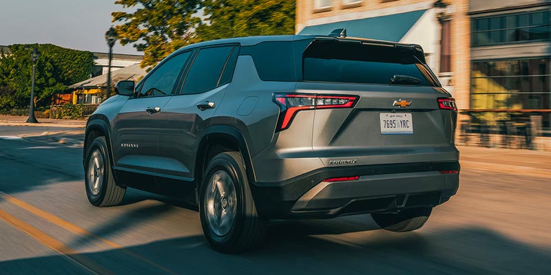 Rear view of Chevrolet Equinox EV driving on a city road demonstrating electric performance