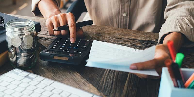 Person using calculator - Vehicle Shopping on a Budget: How to Find the Right Chevrolet Without Overspending